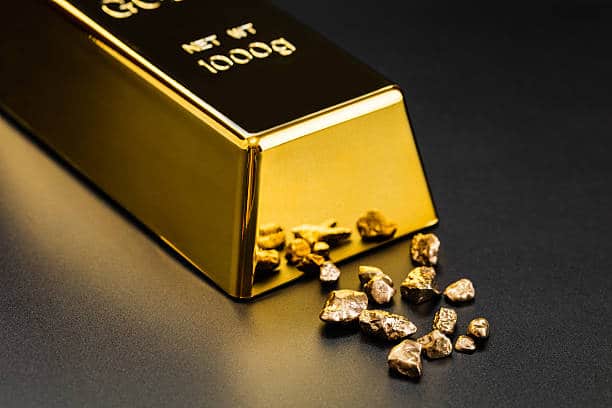 gold bullion and nuggets on a dark background การเก็งกำไร ทองคำแท้