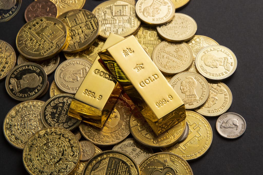 Coins, and gold bars scattered on a table กองทุน SPDR Gold คืออะไร ?
